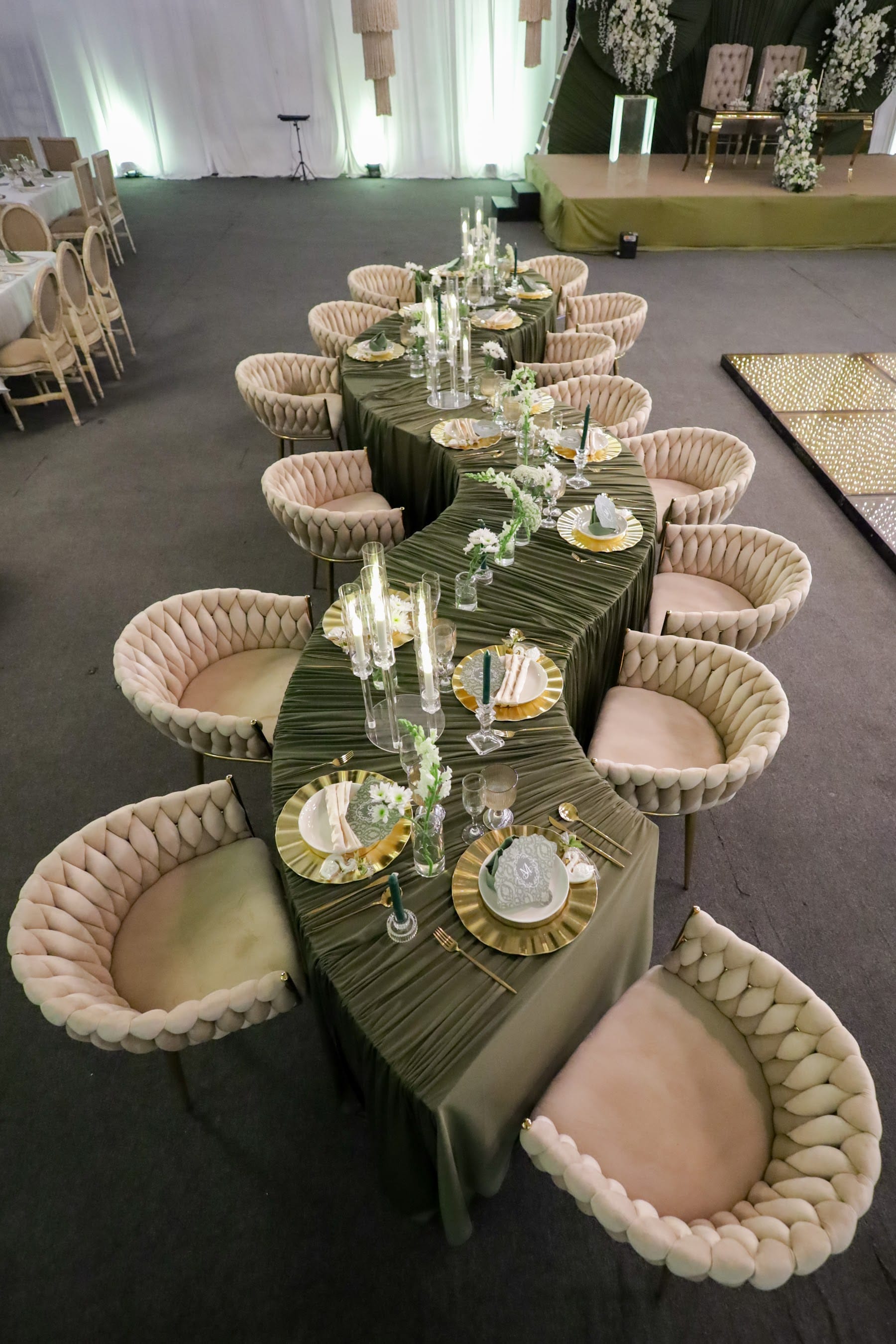 Detalle de mesa con camino de terciopelo verde, copas y sillas tejidas