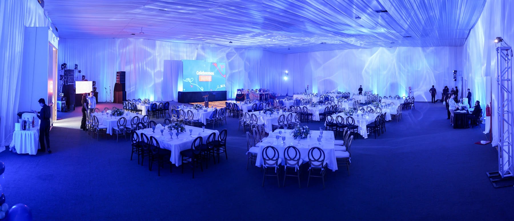 Salón montado para convención con pantallas y luz azul