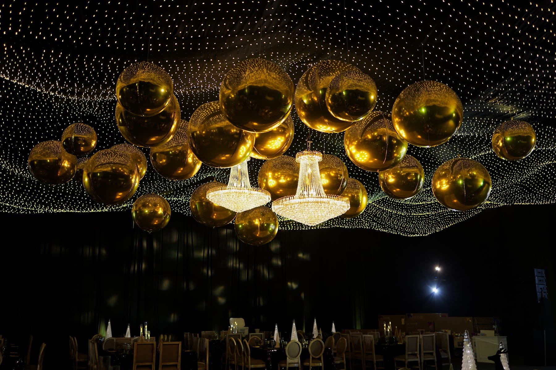 Esferas doradas y cortina de luces sobre una cena de fin de año