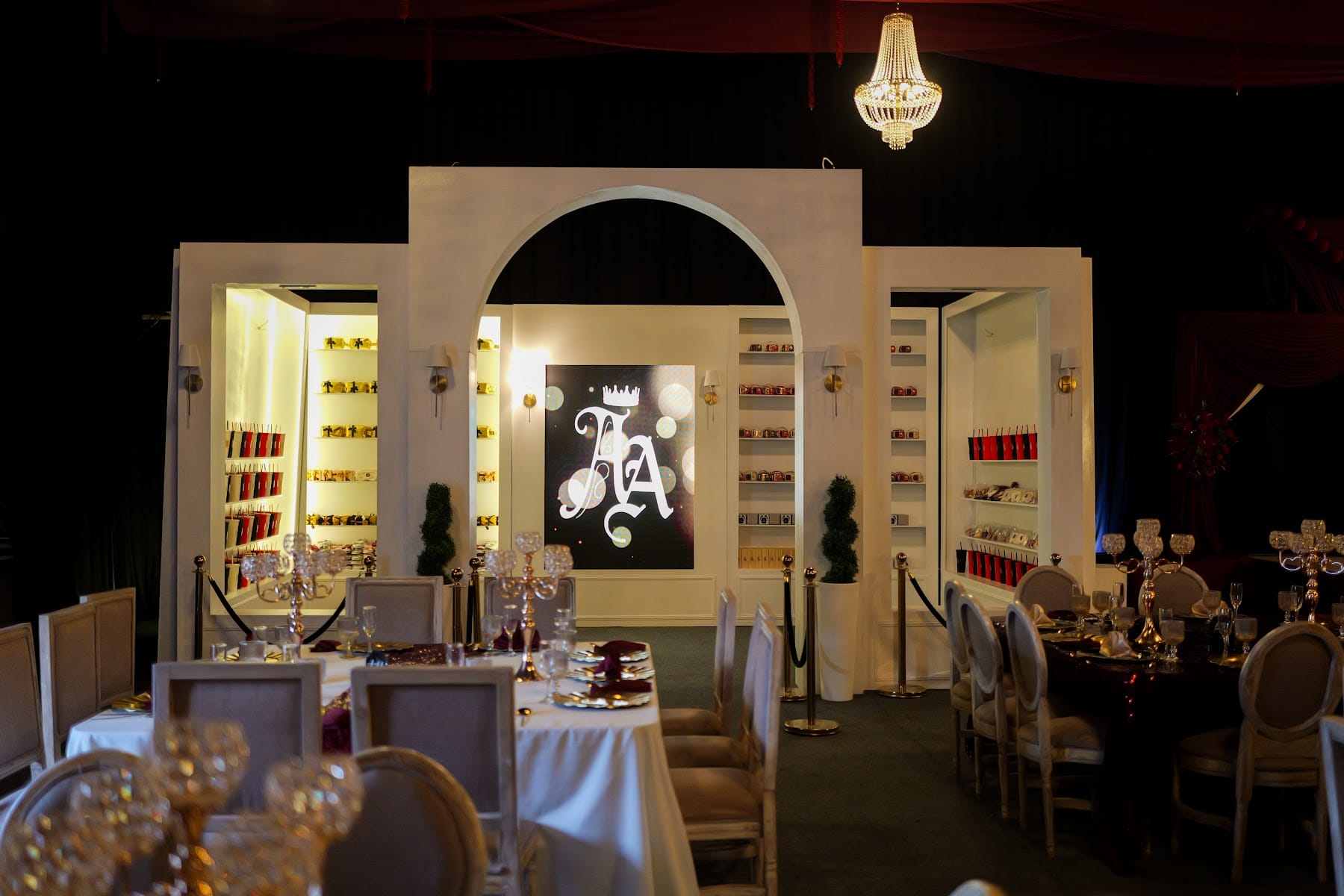 Escenografía de biblioteca blanca con arco, monograma y candelabro para los XV años de Alisson