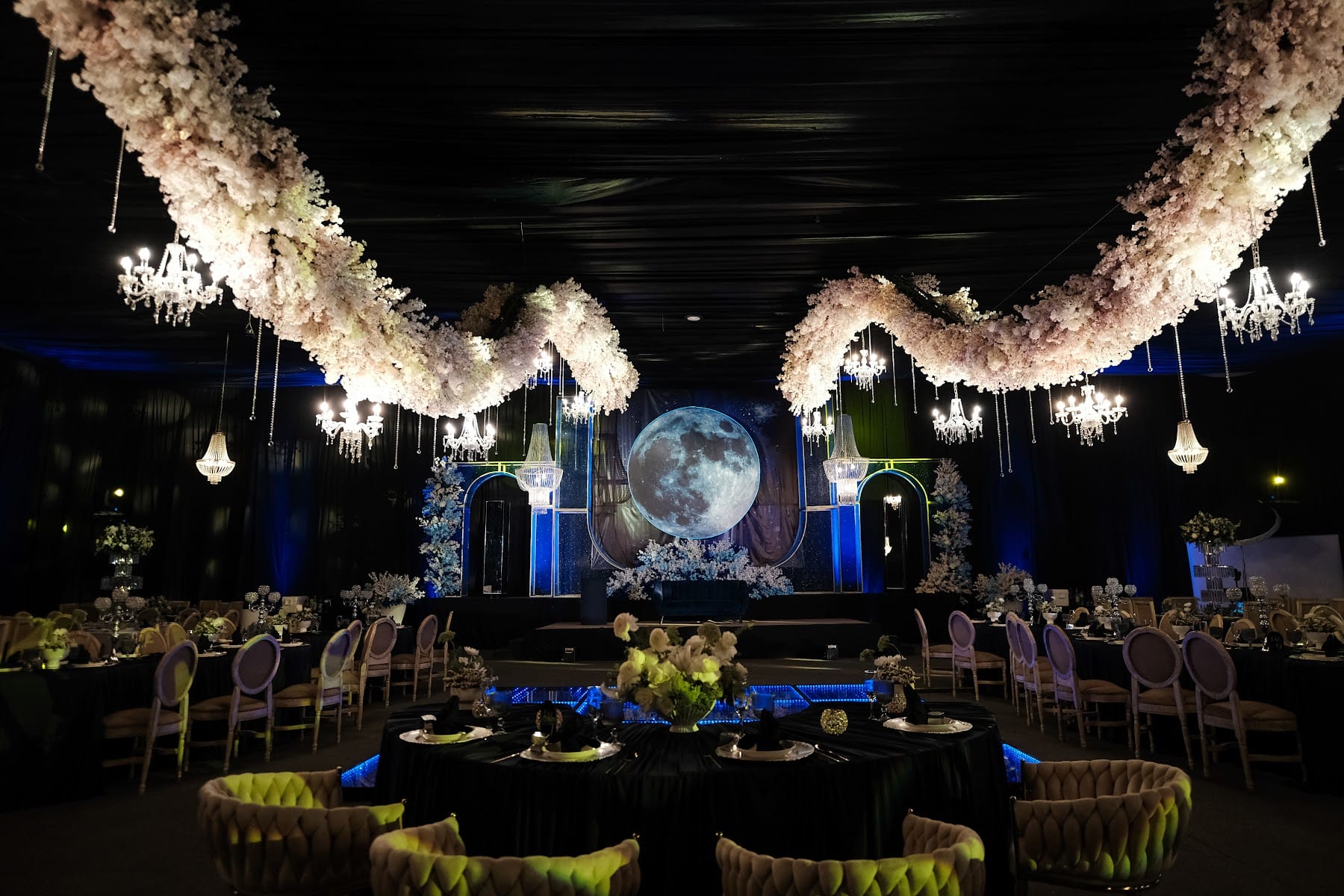 Guirnaldas de flores blancas sobre el salón con luna y luz azul