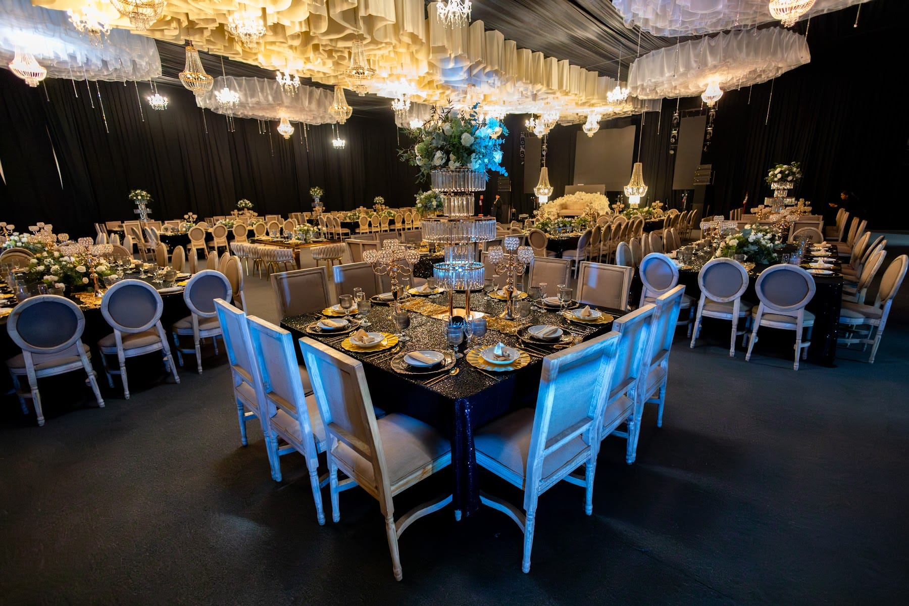 Mesas imperiales bajo un techo de nubes de papel y candiles para los XV años de Mariel