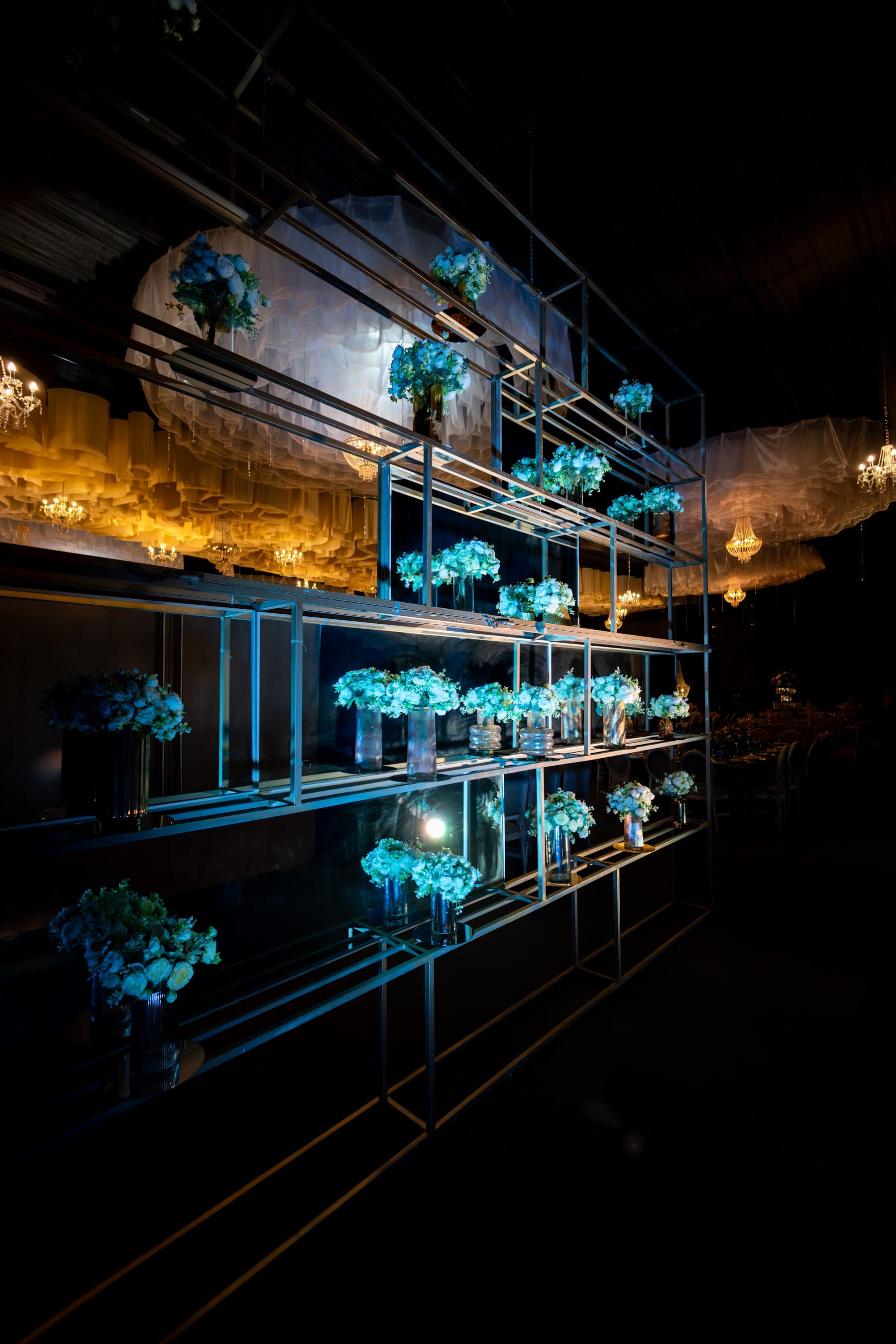 Repisas de cristal con arreglos de flores azules bajo el techo de nubes