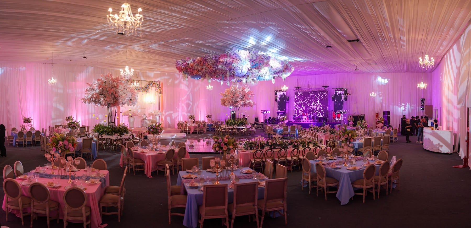 Salón jardín con árboles de flores, mesas rosas y techo floral