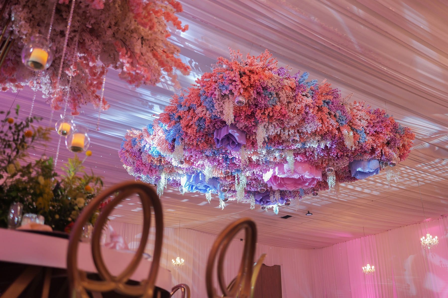 Techo de flores multicolor suspendido sobre el jardín de los XV años de Regina